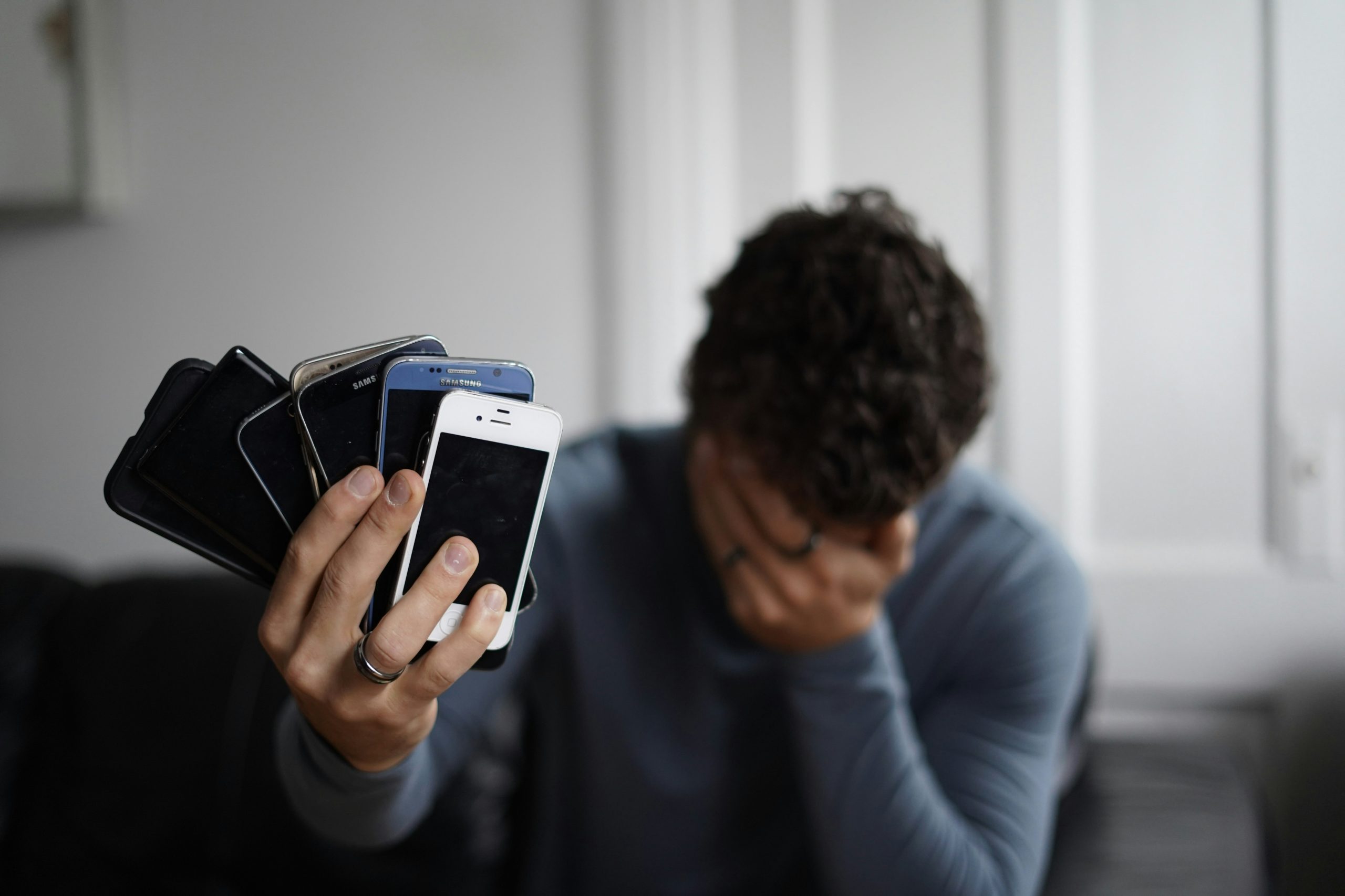 FOMO trên điện thoại Người đang xem điện thoại với biểu đồ tài chính, thể hiện nỗi sợ bỏ lỡ cơ hội (FOMO) trong đầu tư do ảnh hưởng của mạng xã hội.