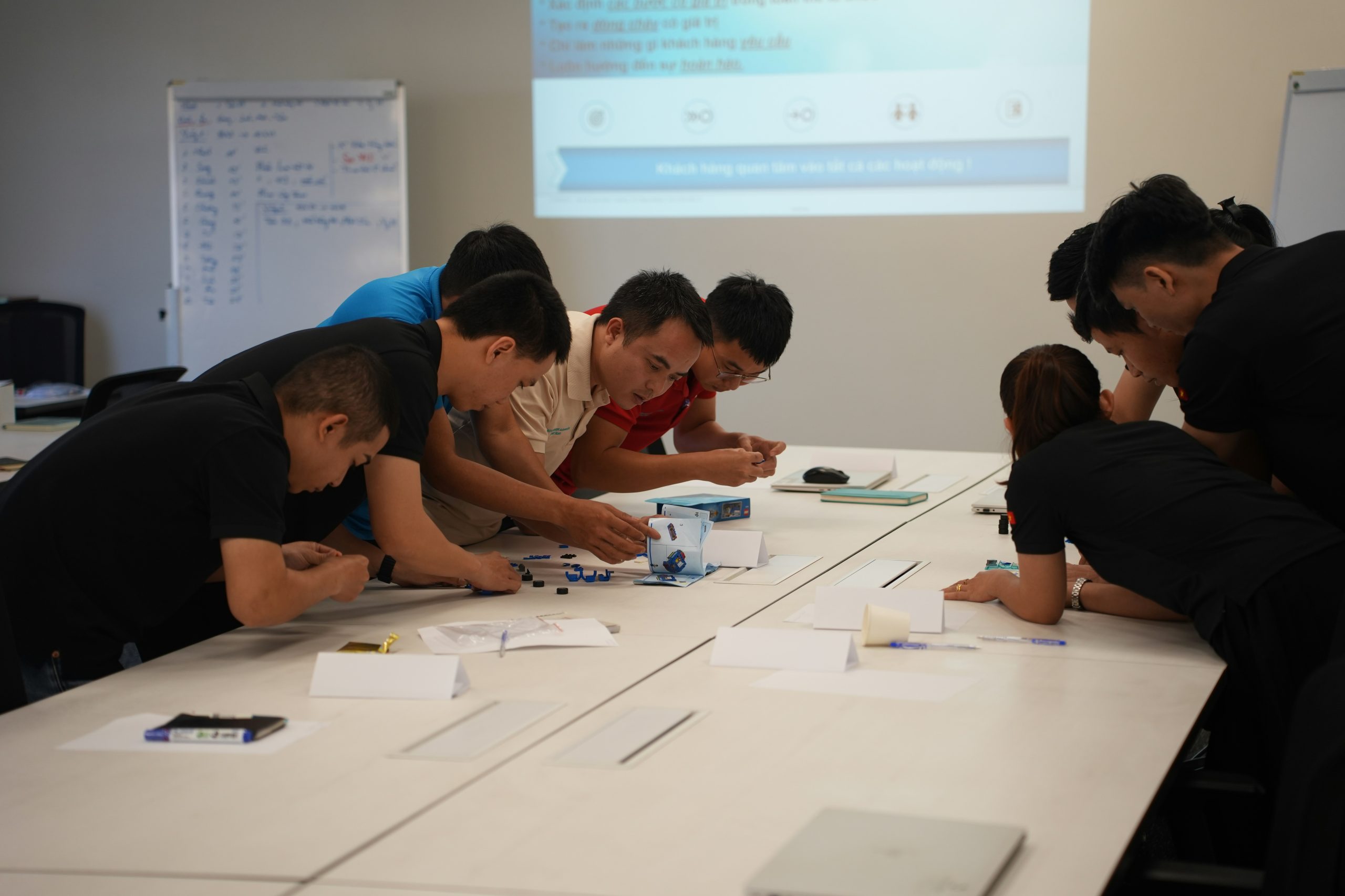 Nhóm người thảo luận chiến lược đầu tư bất động sản tại bảng trắng trong một khóa học bài bản.