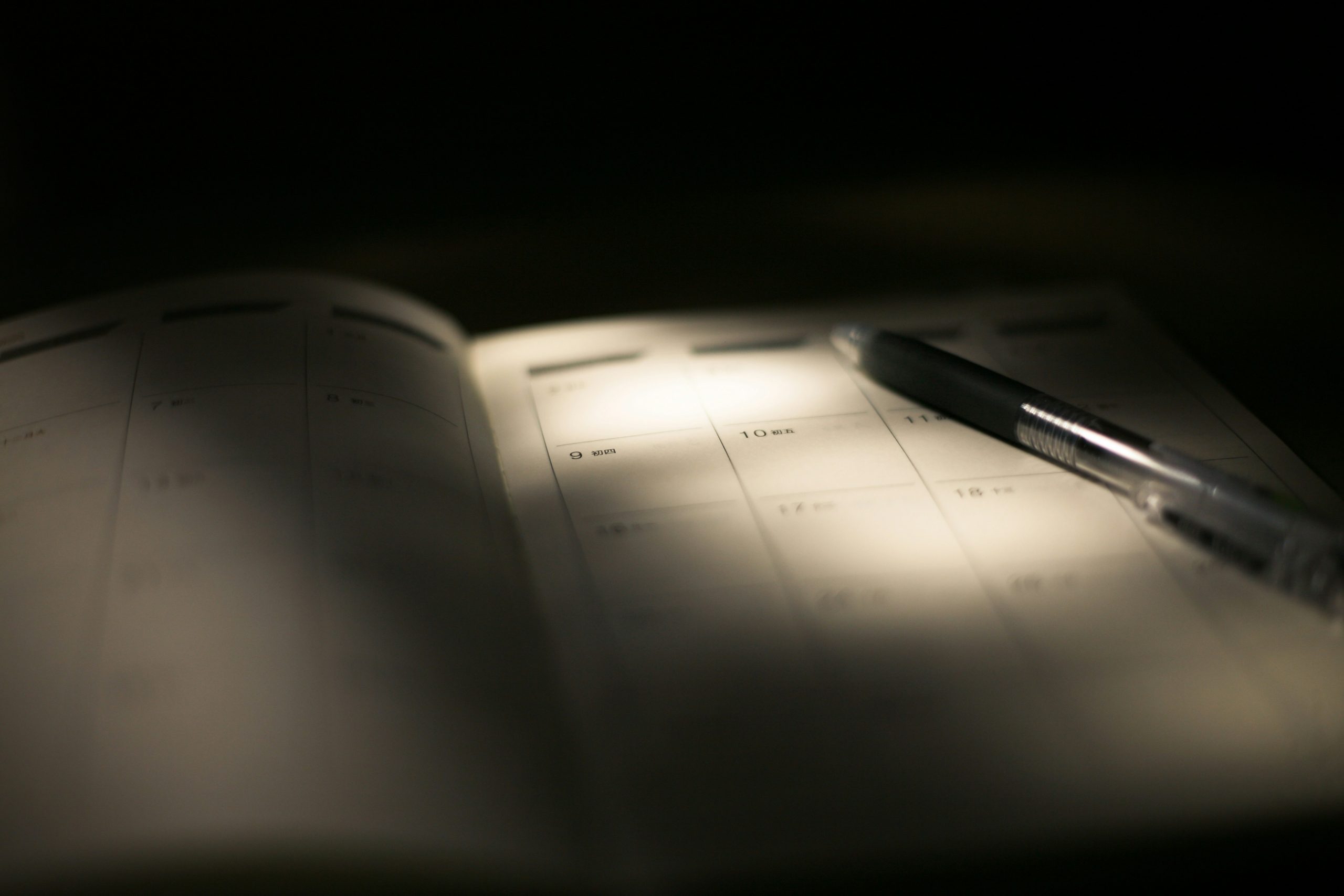 Một người đang ghi lại các khoản chi tiêu vào sổ vào buổi tối, nhấn mạnh tầm quan trọng của việc duy trì thói quen ghi chép hàng ngày để quản lý tài chính hiệu quả.