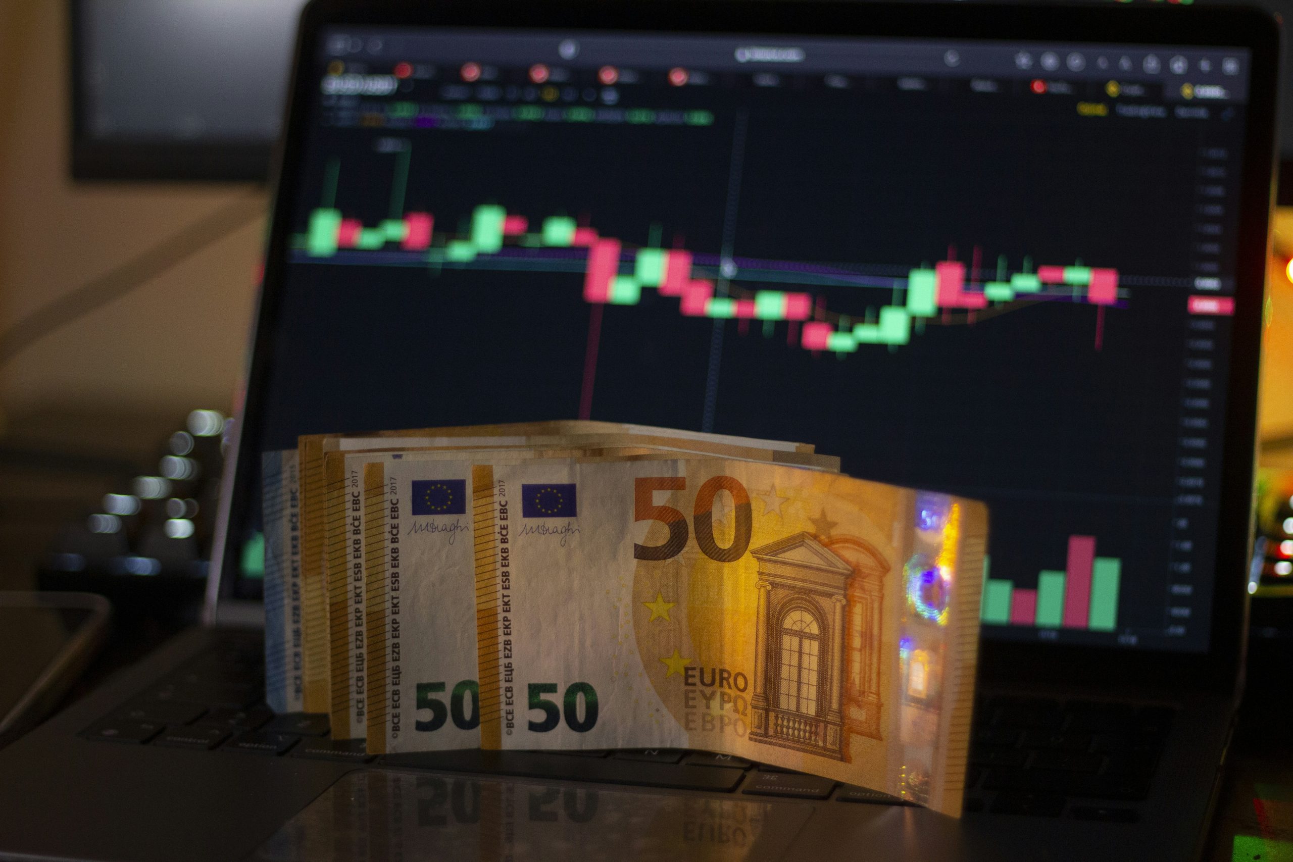 Người giao dịch xem các cặp tiền tệ và biểu đồ nến trên nhiều màn hình, minh họa cơ chế hoạt động của giao dịch Forex.