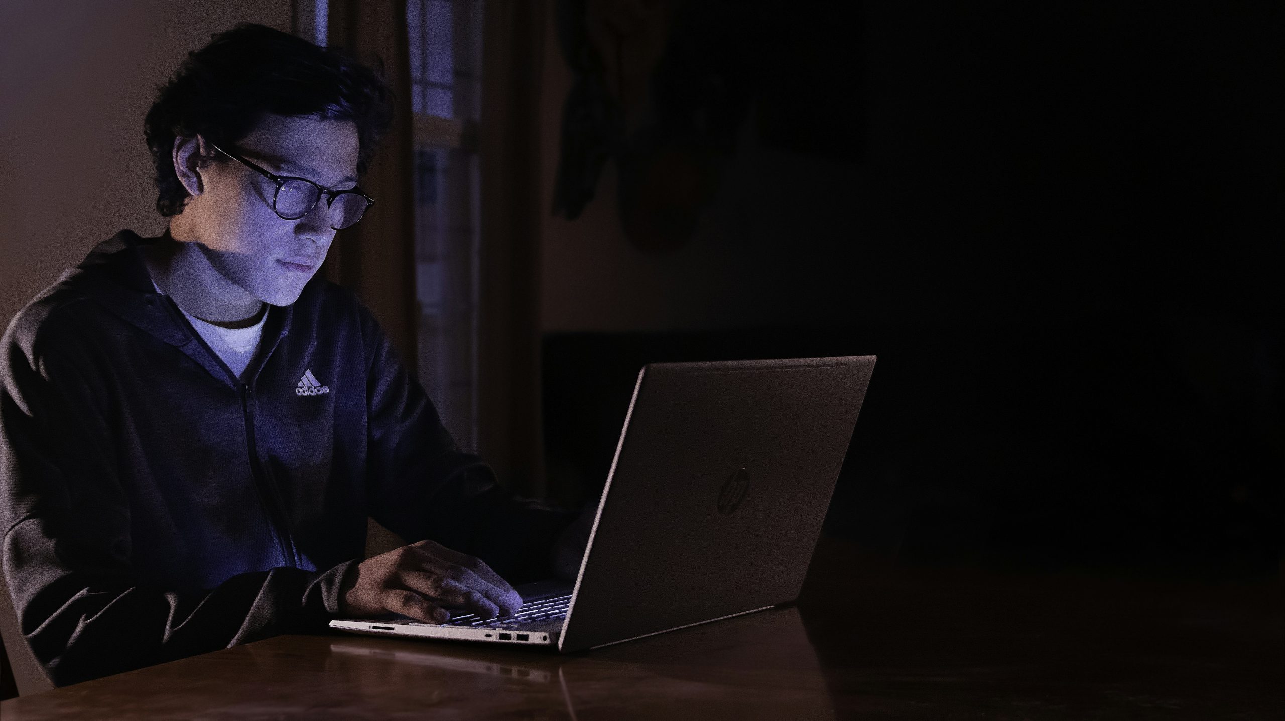 Sinh viên làm việc trên laptop vào ban đêm, quản lý thời gian học tập và công việc online linh hoạt để kiếm thêm thu nhập.